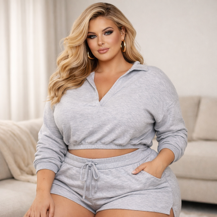Plus size blonde model wearing grey loungewear co-ord set, relaxed fit crop top and shorts in a soft luxury home setting – KissICON loungewear collection