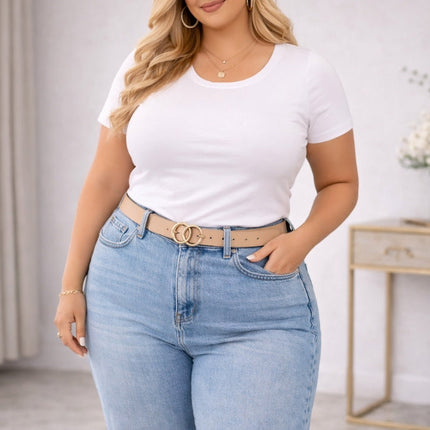 Plus size blonde woman wearing a fitted white t shirt tucked into high waisted jeans in a neutral indoor setting